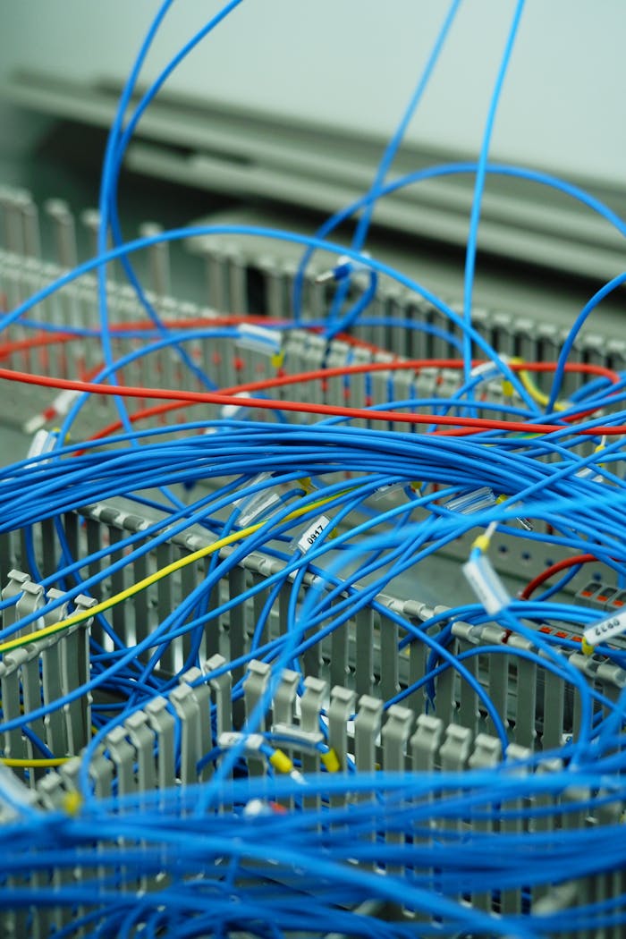 Detailed shot of tangled electrical cables in server room, showcasing technology complexity.